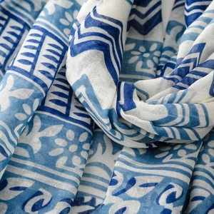 Close-up of lightweight Bali yarn scarf with blue wave patterns and fringed texture
