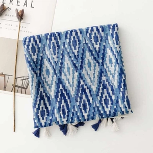 Detailed view of blue geometric woven shawl with tassel edges and ethnic diamond patterns