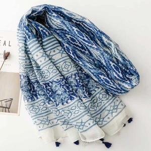Detail of blue and white ethnic geometric pattern scarf with delicate tassels
