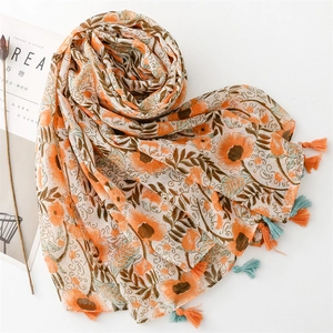 Detailed close-up of orange floral bali yarn scarf with bohemian fringe tassels