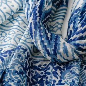 Detail of blue and white floral scarf showing soft fabric folds and intricate weave texture