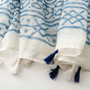 Close-up of blue geometric floral print scarf with soft textures and bicolor tassels