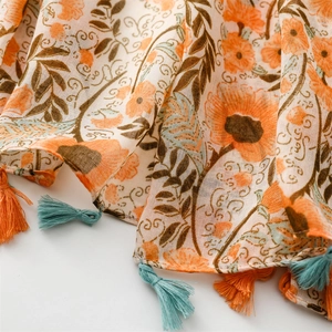 Detail of floral chiffon shawl with orange flowers and vibrant tassel fringe edges
