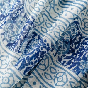 Detailed macro view of thin blue and white geometric floral print fabric with tassels