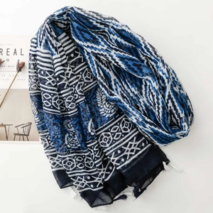 Detailed view of blue and white ethnic geometric pattern shawl with white tassels