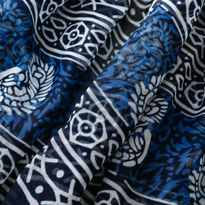 Macro detail of blue and white porcelain pattern on soft tasseled voile scarf fabric