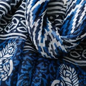 Detail of blue geometric and floral patterns on lightweight woven tassel scarf fabric