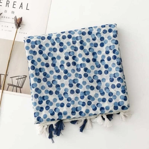 Detail of blue polka dot scarf featuring tassel trim and a minimalist Nordic texture