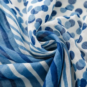 Detail of blue and white polka dot scarf fabric with light texture and tassels