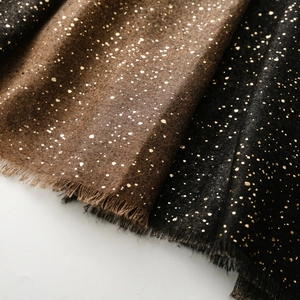 Detailed texture of thick cotton linen shawl with gold foil accents and fringe edges