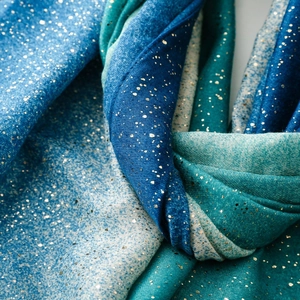 Close-up of gradient blue scarf with gold foil accents and soft cotton linen texture