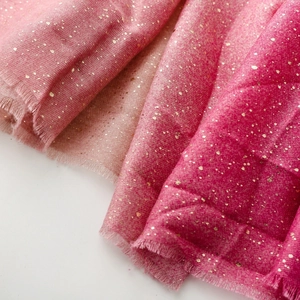 Close-up of pink gradient cotton linen scarf with gold foil accents and fringe trim