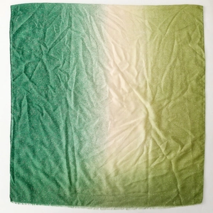 Macro detail of green and cream gradient scarf with shimmering metallic finish and crinkled texture