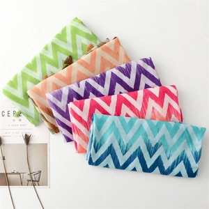 Detail of colorful zigzag wave scarves with tassels in green orange pink blue and purple