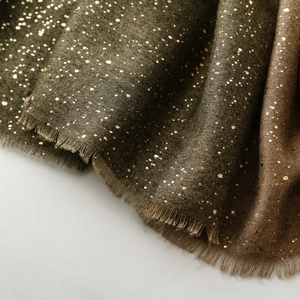 Detailed macro view of gradient cotton-linen scarf with gold foil dots and fringe hem