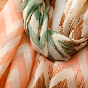 Detailed texture of cotton linen scarf featuring orange and green wave patterns and tassels