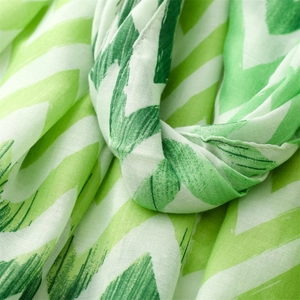Close-up detail of green wave pattern cotton linen scarf showing soft fabric texture