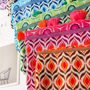 Detail of bohemian scarf with colorful geometric patterns and handmade fringe tassels