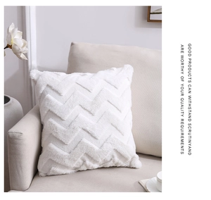 Close-up of white plush cushion cover with tufted chevron pattern on a beige sofa