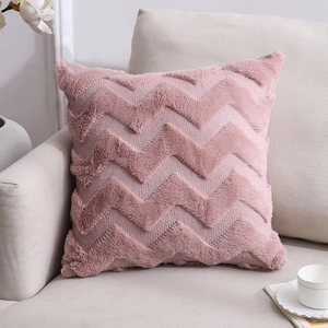 Nordic pink faux fur pillow with zigzag pattern on a sofa in a warm living room