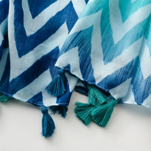 Detail of blue and white wave pattern scarf with handcrafted fringe tassels