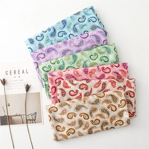 Vue détaillée de foulards colorés avec motif Paisley, dorure et bords à franges fins