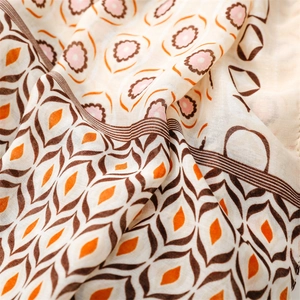 Detail of bohemian scarf showing soft linen texture with pink floral and orange patterns