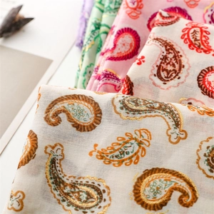 Détail macro du motif cachemire sur une écharpe douce en coton et lin avec dorures