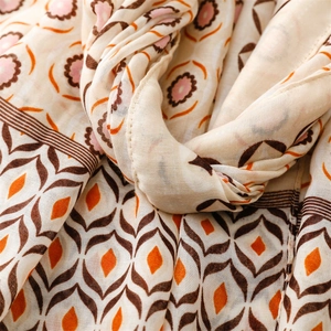 Detailed macro view of geometric diamond patterns and fringe trim on soft linen shawl