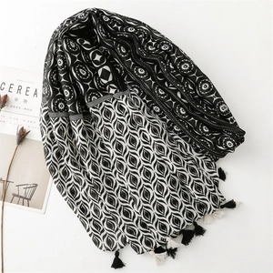 Detail of bohemian geometric scarf with monochrome patterns and tassel fringes