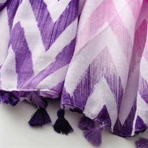 Close-up of zigzag wave pattern fabric with purple fringes and woven texture shawl