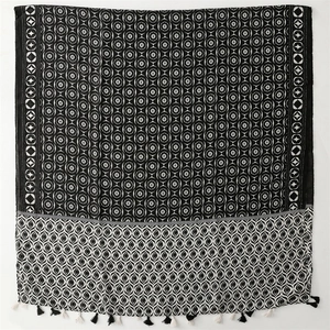 Detail of cotton linen shawl featuring geometric patterns and black white fringe tassels