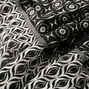 Close-up of geometric star moon print and fine linen texture on a fringed scarf