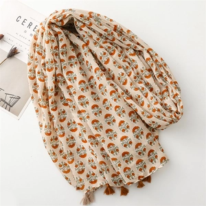 Detail of floral linen scarf with tassels and retro flower print on beige fabric