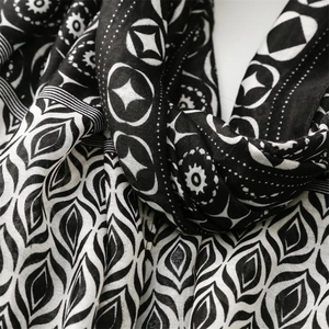 Detail shot of black and white scarf featuring celestial star and leaf pattern textures