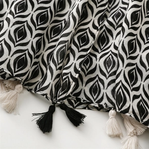 Close-up of black and white geometric pattern and tassels on the cotton linen scarf