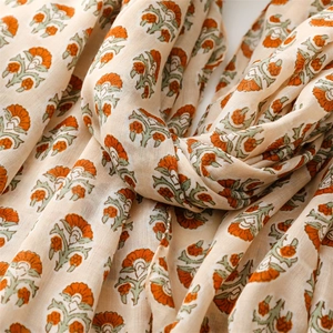 Close-up of floral print scarf with orange flowers and soft fringe detailing