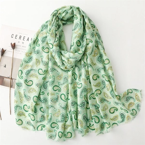 Écharpe vert clair en coton et lin avec motif paisley doré et bords effilochés
