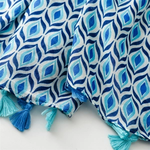 Detail of blue geometric print scarf featuring soft cotton-linen fabric and tassel fringe
