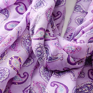 Détail d'une écharpe lilas au toucher lin avec motifs paisley dorés et texture douce