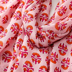 Detail of floral print scarf showing soft cotton-linen texture and orange flower patterns