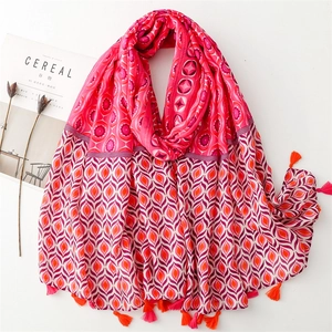 Detail of bohemian scarf with pink and orange tassels and geometric patterns