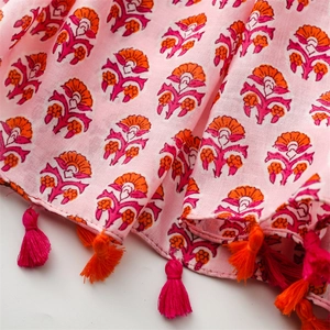 Detail of pink cotton linen scarf with ethnic floral print and colorful handmade tassels