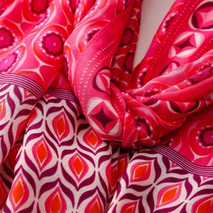 Detailed macro view of bohemian geometric diamond pattern on a soft pink linen scarf