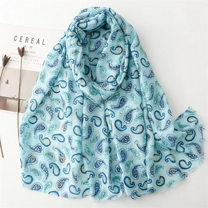 Détail d'une écharpe en coton et lin bleu clair à motif paisley et bords effilochés