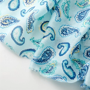 Gros plan d'un foulard cachemire bleu clair avec dorure à la feuille et bords effilochés