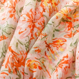 Close-up of lightweight floral scarf fabric showing delicate orange honeysuckle prints