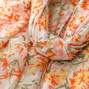 Macro shot of lightweight floral scarf showing orange flower print and weave texture