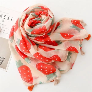 Close-up of lightweight strawberry print scarf with soft tassels and pastoral patterns
