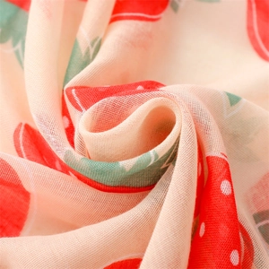 Macro shot of breathable linen cotton scarf fabric with red strawberry print detail